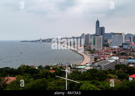 Yantai, China - mit Blick auf die Küstenlinie von Yantai Shan, der Hügel in der Altstadt mit einem Leuchtturm, ein Tempel und das Smoke Signal Terrasse, t gibt Stockfoto