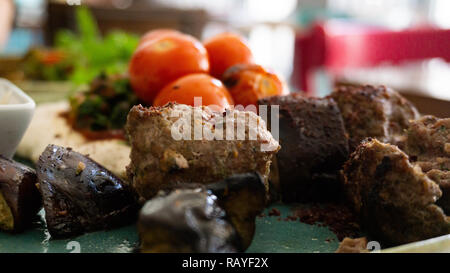 Typisch für die libanesischen Gericht basierend auf Stücke von Fleisch ist gebratenes Hackfleisch mit einer Seite der gekochten Tomaten Stockfoto