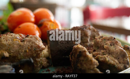 Typische libanesischen Gericht auf Stücke Fleisch basiert gebratene Hackfleisch mit einer Seite der gekochten Tomaten Stockfoto