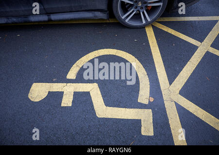 Ein Auto Rad geparkt schlecht auf die Platz für Behinderte Parken erforderlich Stockfoto