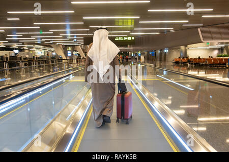 Arabische Passagier auf Fahrsteig in Terminal Gebäude im modernen Hamad internationaler Flughafen in Doha, Katar Stockfoto