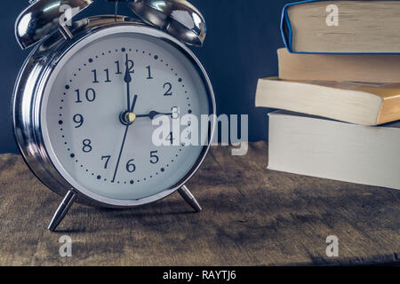 Vintage Wecker und einem Stapel Bücher. Lesen oder Bildung conpept. Stockfoto