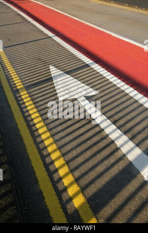 Weißer Pfeil auf der Fahrbahn. Stockfoto