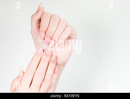 Nahaufnahme von zwei weiblichen weißen Hände mit alten Gel poliert Maniküre benötigen Korrektur nach mehreren Wochen tragen. Vertikale Farbfotografie. Stockfoto