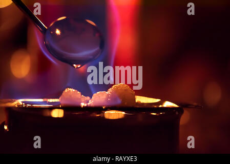 Feuerzangenbowle: blaue Flamme Feuer mit farbigem Hintergrund Stockfoto