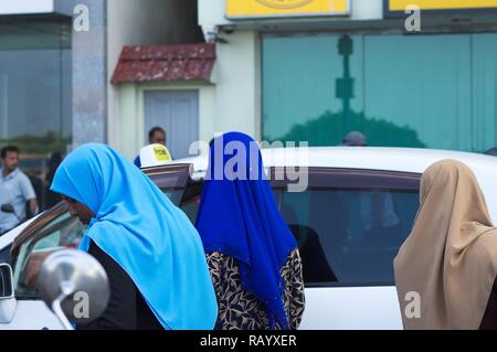 Male, Malediven - 20. Dezember 2018: Drei maledivische Frauen mit farbigen Schleier (muslimische Religion) Stockfoto