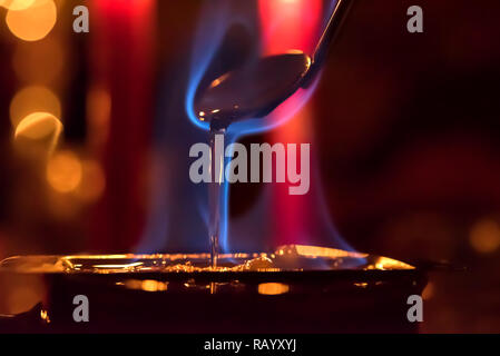 Feuerzangenbowle: blaue Flamme Feuer mit farbigem Hintergrund Stockfoto