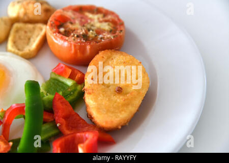 Frühstück mit Rührei, Spiegelei Brötchen und Gemüse Stockfoto