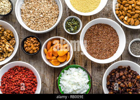 Tabelle mit Nahrung, Auswahl der Superfoods, Müsli, Früchte, Beeren, Nüsse, Samen, Bestandteile von gesundes Frühstück Stockfoto