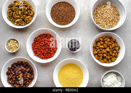 Vegetarisches Frühstück mit gesunden Lebensmitteln Auswahl, Nüsse, Samen, Goji Beeren und andere superfoods auf Tisch, Flach, Overhead Stockfoto