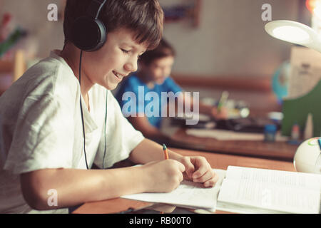 Jungen jungen Hausaufgaben machen oder Lernen zu Hause Stockfoto