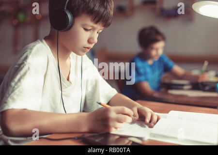 Jungen jungen Hausaufgaben am Schreibtisch, im Innenbereich Stockfoto