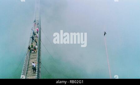 Peking, der chinesischen Provinz Zhejiang. 25 Aug, 2018. Die Menschen sehen ein Mann zu Fuß auf einem gurtband beim Slacklining Wettbewerb im malerischen Ort Shenxianju Xianju County, in der ostchinesischen Provinz Zhejiang, Aug 25., 2018. Credit: Zhu Cheng/Xinhua/Alamy leben Nachrichten Stockfoto