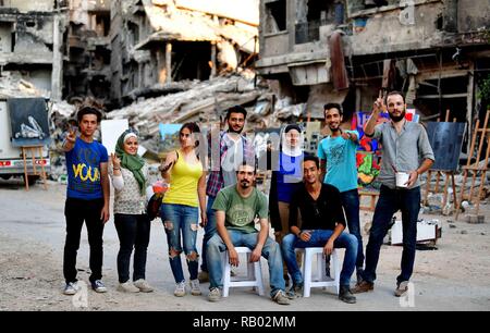 Peking, China. 16 Aug, 2018. Syrische Künstler flash den Sieg Zeichen inmitten der Trümmer und der Vernichtung der Yarmouk Camp, südlich von Damaskus, Syrien, am 12.08.16, 2018 Credit: Ammar Safarjalani/Xinhua/Alamy leben Nachrichten Stockfoto