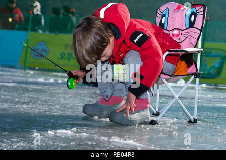 Hwacheon, Südkorea. 5 Jan, 2019. Ein Junge Fische für Forellen auf einem zugefrorenen Fluss während der Sancheoneo Ice Festival in Hwacheon, Südkorea, Jan. 5, 2019. Als einer der größten Winter Veranstaltungen in Südkorea, die jährlichen dreiwöchigen Festival Leute auf dem gefrorenen Fluss, wo die Organisatoren Hwacheon bohren der Löcher im Eis und Forellen in den Fluss während der Festspielzeit zeichnet. In diesem Jahr das Festival dauert vom 5. bis 14.01.27. Credit: Wang Jingqiang/Xinhua/Alamy leben Nachrichten Stockfoto