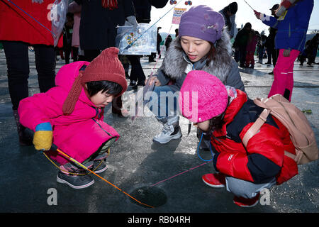 Hwacheon, Südkorea. 5 Jan, 2019. Die Leute fischen für Forellen auf einem zugefrorenen Fluss während der Sancheoneo Ice Festival in Hwacheon, Südkorea, Jan. 5, 2019. Als einer der größten Winter Veranstaltungen in Südkorea, die jährlichen dreiwöchigen Festival Leute auf dem gefrorenen Fluss, wo die Organisatoren Hwacheon bohren der Löcher im Eis und Forellen in den Fluss während der Festspielzeit zeichnet. In diesem Jahr das Festival dauert vom 5. bis 14.01.27. Credit: Wang Jingqiang/Xinhua/Alamy leben Nachrichten Stockfoto