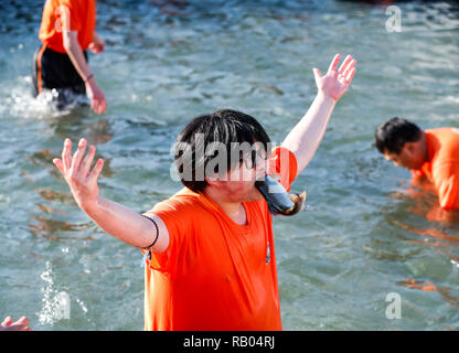 Hwacheon, Südkorea. 5 Jan, 2019. Ein Mann hält eine Forelle mit seinen Mund in einem Fluss während der Sancheoneo Ice Festival in Hwacheon, Südkorea, Jan. 5, 2019. Als einer der größten Winter Veranstaltungen in Südkorea, die jährlichen dreiwöchigen Festival Leute auf dem gefrorenen Fluss, wo die Organisatoren Hwacheon bohren der Löcher im Eis und Forellen in den Fluss während der Festspielzeit zeichnet. In diesem Jahr das Festival dauert vom 5. bis 14.01.27. Credit: Wang Jingqiang/Xinhua/Alamy leben Nachrichten Stockfoto