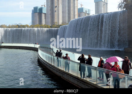 Kunming, Provinz Yunnan in China. 5 Jan, 2019. Touristen besuchen Sie Kunming Wasserfall Park in Kunming, der Hauptstadt der Provinz Yunnan im Südwesten Chinas, Jan. 5, 2019. Der Park verfügt über einen großen künstlichen Wasserfall, der 12,5 Meter in der Höhe und 400 Meter in der Breite. Der Wasserfall ist Teil des Projekts Umleitung von Wasser aus dem Fluss in Niulan Dianchi See. Credit: Qin Qing/Xinhua/Alamy leben Nachrichten Stockfoto