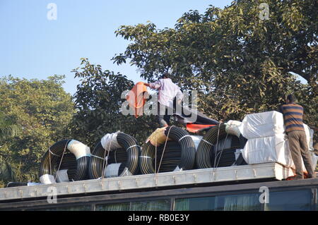 Kolkata, Indien. 6. Januar, 2019. Arbeiter entlädt waren vom Dach des über Nacht gespielt, Bus inter. Credit: Biswarup Ganguly/Alamy leben Nachrichten Stockfoto