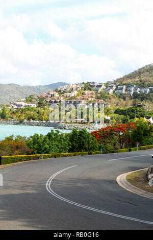 Blick auf die Stadt von Airlie Beach mit der Straße in den Vordergrund und Ferienhäusern als Hintergrund (Airlie Beach, Queensland, Australien) Stockfoto