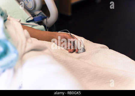 Gefilterten Bild Frau hand mit Pulsoximeter und Herzfrequenz fin Stockfoto