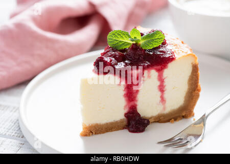 Käsekuchen mit Kirschen. Detailansicht der klassischen New York Cheesecake serviert mit süßen Beeren-Sauce Stockfoto