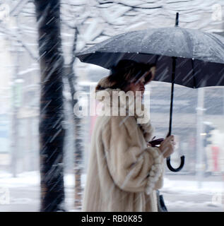 Belgrad, Serbien - Dezember 15, 2018: Blurry stilvolle ältere Frau allein unter dem Dach in starker Schneefall Stockfoto