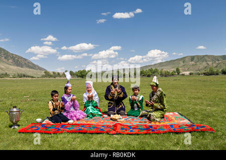 Kasachische Familie alle gemeinsam beten, bevor Sie beginnen, Ihre Picknick Mittagessen im Dorf bleiben, Kasachstan. Stockfoto