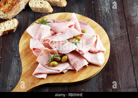 Schinken auf Holz- Hintergrund. Frische Prosciutto. Schweinefleisch Schinken in Scheiben geschnitten. Stockfoto
