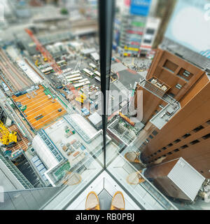 Asien Business Konzept für Immobilien und Corporate Bau-Mann stehen neben Fenster mit Sicht auf die City Skyline Luftbild in Shibuya, Tokio, Japan Stockfoto