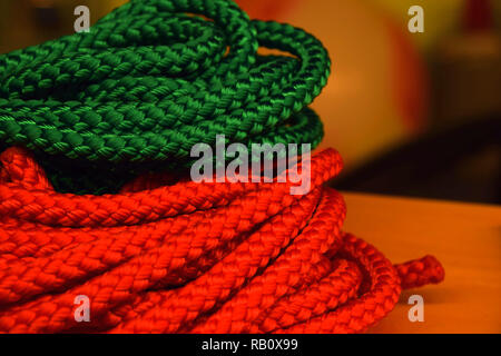 Grün und Orange nylon Seile abstrakten Blick vor dem hellen Hintergrund, neue orange und grün Seile Makro geschossen für den Versand oder die Gesundheit oder Sport Stockfoto