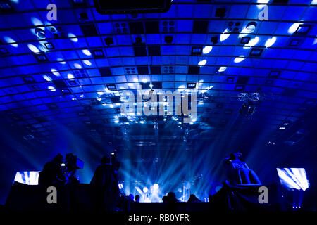 Fernsehen von einem Kameramann bei einem Konzert. Kamera mit dem Operator ist auf der Plattform. Silhouetten auf dem Hintergrund der bunte Strahl Stockfoto