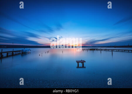 Kleine Dock und Boot am See, Sonnenuntergang geschossen Stockfoto