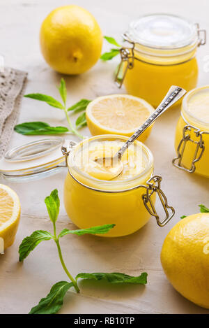 Frische hausgemachte Lemon Quark in Gläsern an der konkreten Hintergrund. Selektive konzentrieren. Stockfoto