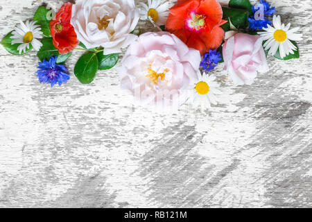 Einladung Hochzeit oder Jubiläum Grußkarte oder Muttertag Karte mockup mit Rosen, Mohn und Wildblumen auf weißen hölzernen Tisch dekoriert mit b Stockfoto