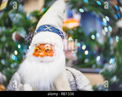 Spielzeug Weihnachtsmann, gegen einen festlichen hellen weichen konzentriert bokeh Hintergrund. Weihnachten und Neujahr Konzept. Stockfoto