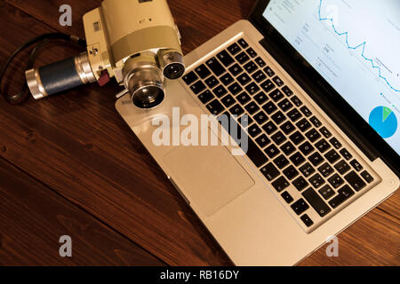 Kontrast zwischen verschiedenen Perioden der Technologie: vintage Super 8 Cine-Kamera aus den 60er Minolta Zoom 8 mit einer tatsächlichen Computer laptop Apple Macb Stockfoto