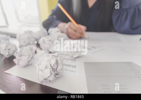 Keine Idee und Konzept f-Geschäftsfrau, Sitzen mit zerknittertem Papier oder Müll und Papier Kugel oder Abfälle auf den Boden, Geschäftsmann sind Verkrümmung ein Papier Stockfoto