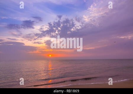 Am Strand der ruhigen endlosen Meer. Multicolor Sonnenuntergang und Wolken Stockfoto