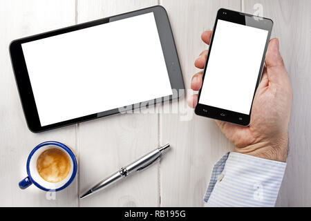 Topview Geschäftsmann smartphone Holding weiter mit leeren Bildschirm auf weiße Holztisch zu Tablet Stockfoto