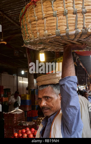Ein Portier mit seinen Korb in Mahatma Jyotiba Phule Market oder Crawford Market, einem kolonialen Ära Markt für Obst und Gemüse in Mumbai, Indien Stockfoto