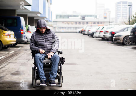 Junge, Erwachsene Rollstuhlfahrer auf einem Parkplatz mit Platz kopieren Stockfoto