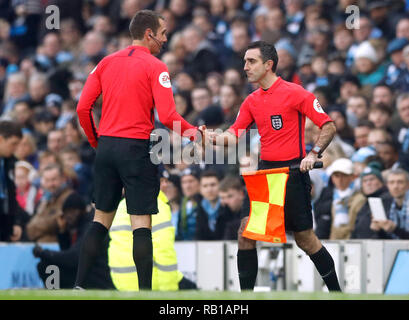 Vierte Offizielle Paul Marsden (rechts) spricht mit Schiedsrichter David Coote als kommt auf Simon Lange als Linienrichter während der Emirate FA Cup zu ersetzen, dritte Runde am Eithad Stadion, Manchester. Stockfoto