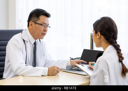 Zwei Ärzte im Krankenhaus die Diagnos des Patienten besprechen Stockfoto
