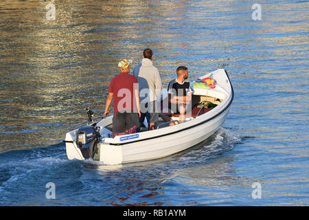 Die Leute, die eine Reise auf dem Fluss im Sommer in Großbritannien, in einem kleinen Boot mit Außenbordmotor. Stockfoto