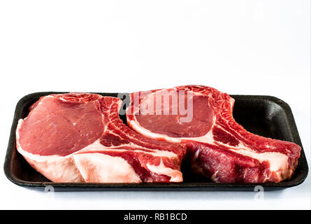 Blick von oben auf die schwarzen Schaum essen Fach mit Raw-marmoriertem Fleisch steak isoliert auf weißem Stockfoto