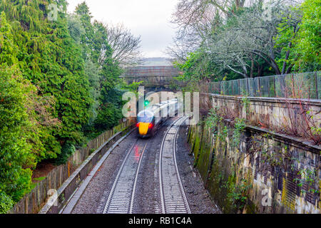 Ein fahrender Zug von oben gesehen mit Bewegungsunschärfe durch Sidney Gärten und unter dem beckford Straße Brücke in der Stadt Bath Somerset UK gehen Stockfoto