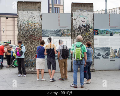 BERLIN, DEUTSCHLAND - 26. JUNI 2017: Touristen in einem Teil der ehemaligen Berliner Mauer Suchen am Potsdamer Platz in Berlin. Stockfoto