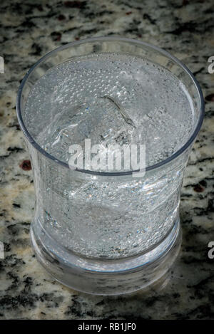 Glitzernde Wasser in einem tumbler Stockfoto