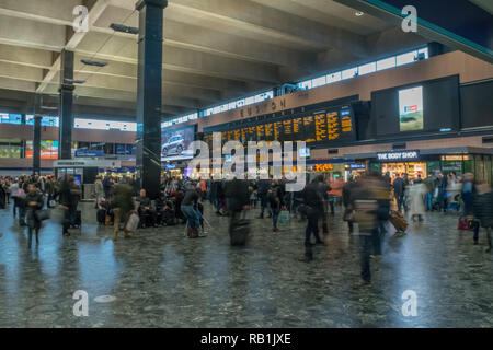 Passagiere in London Euston Station, London, England auf die bahnhofshalle Züge warten Stockfoto